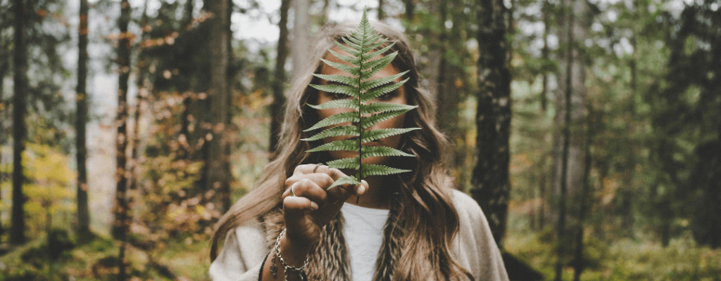 woman with pcos holding plant infront of her face